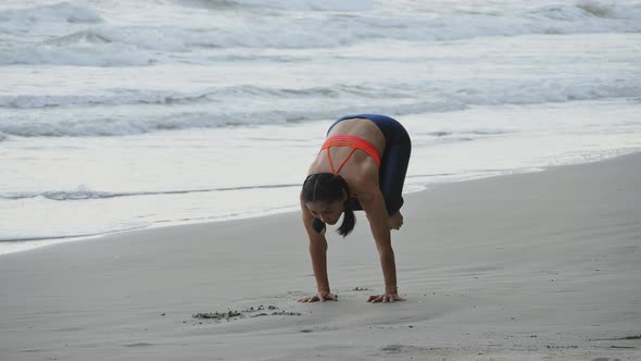 Asian woman is practicing yoga position on the beach.