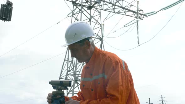 Aged Survey Specialist Adjusts Dumpy Level on Tripod