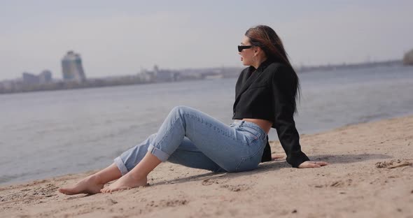 Woman Sitting on the Beach and Relaxes