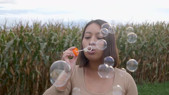 Asian woman having fun outdoors and blowing soap bubbles.Childhood memories.Slow motion footage.