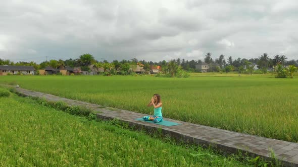 Slowmotion Aerial Shot of a Young Woman Doing Meditation for Muladhara Chakra in a Balinese Way