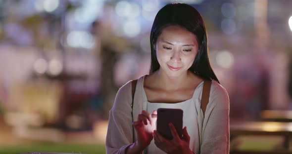 Woman use of mobile phone in coffee shop at night