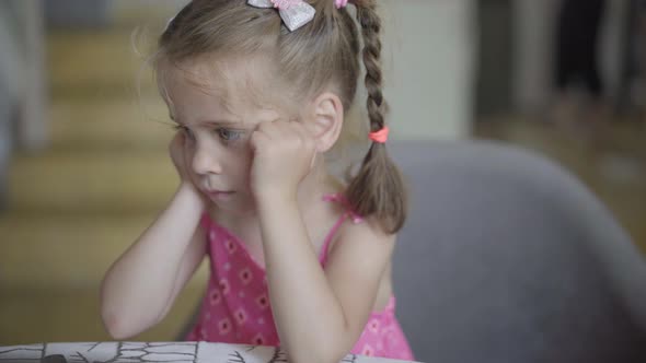 Little Girl Ponytail Sitting Dinner TAble Close Up Portrait Sad Emotion Worried Caucasian Female