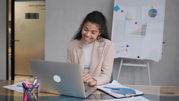 Black Woman Smiling While Speaking or Chatting on Video Call in Office