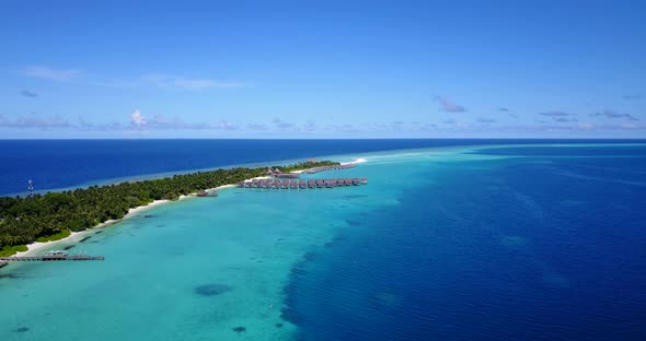 Wide birds eye clean view of a white sand paradise beach and turquoise sea background in 4K