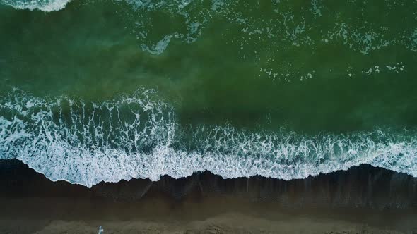 Aerial Drone Footage. Top View Waves on Beach at Evening