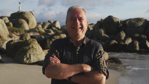 Senior man smiling at camera at the beach