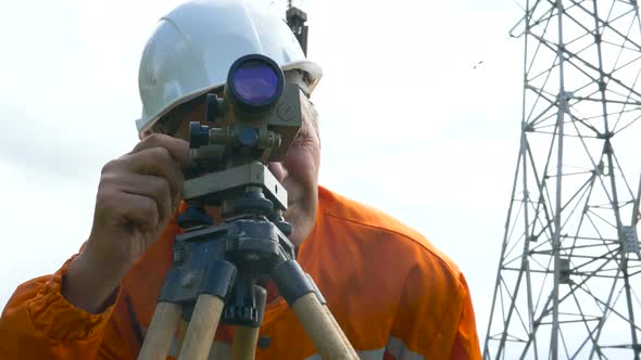 Explorer in Jumpsuit Looks Through Dumpy Level Binocular