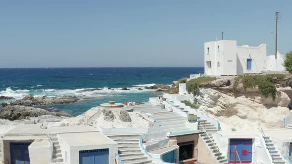 Aerial Trough Scenic Little Greek Fishing Village with Typical White Houses Right at the Aegean