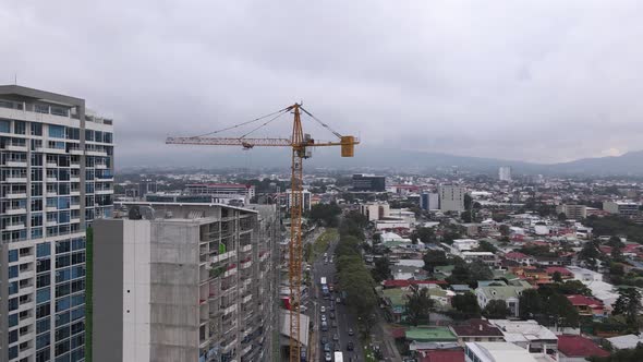 Drone shot of a crane constructing a skyscraper in San Jose city, Costa Rica