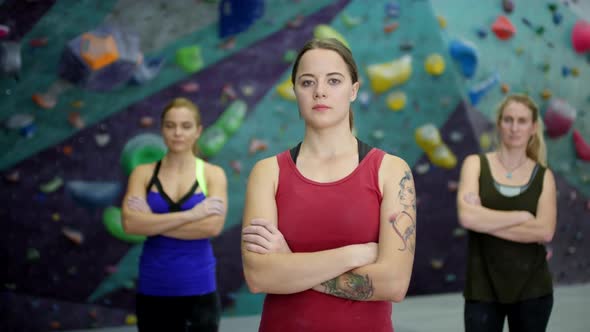 Three Caucasian Female Climbers Posing next to Indoor Wall