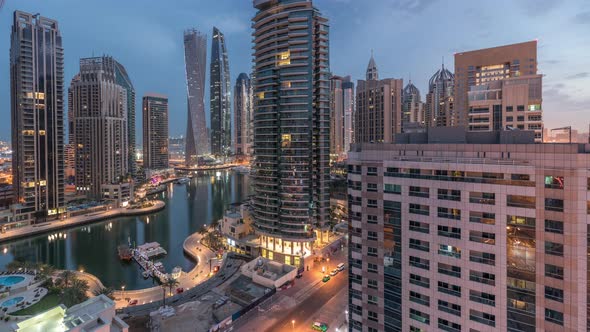 Aerial View of Dubai Marina Residential and Office Skyscrapers with Waterfront Night to Day