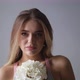 Attractive Woman Smiling at the Camera, with a White Bouquet in Her Hands - VideoHive Item for Sale