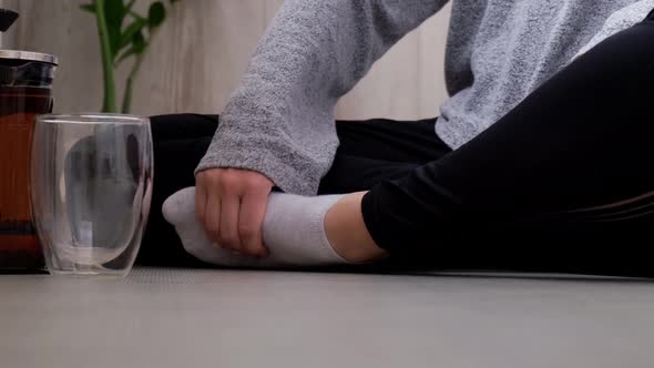 Young Millennial Blonde Woman Drinking Tea and Doing Yoga Exercise Stretching Fitness at Balcony