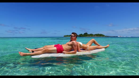 Boy and girl in love on beautiful seashore beach trip by clear water with white sand background of t