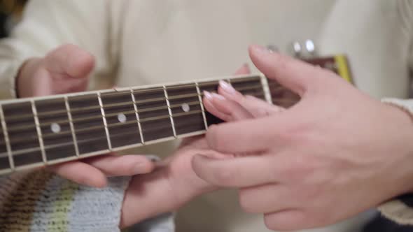 Closeup of Female Hand on Guitar Fingerboard