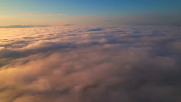 4K Aerial view from drone over mountains and sea of fog. Golden scenery at sunrise