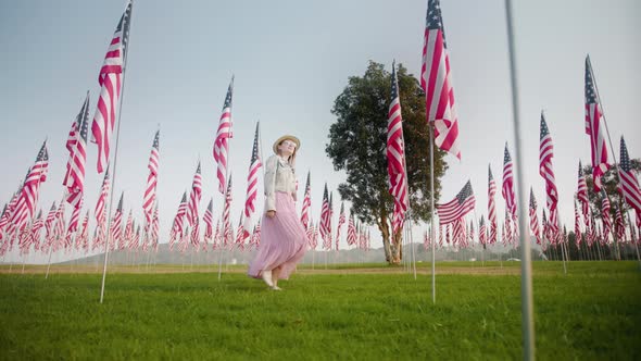 Young Woman Walking Between Flagpoles on Summer Day Independence or Labor Day