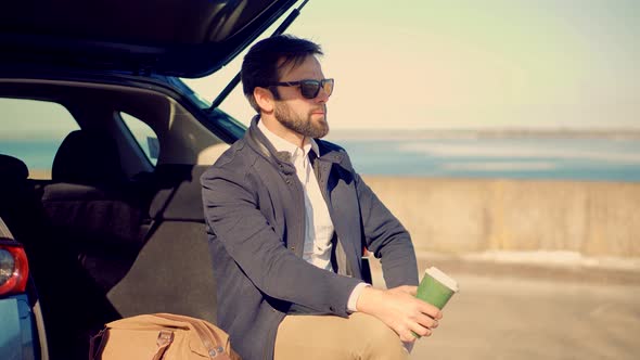 Businessman Relaxing And Drinking Coffee. Lonely Handsome Confident Man In Suit Thinking Outdoors.