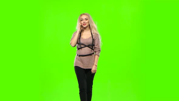 Girl with Long Curly Hair Talking on the Phone and Smiles Sweetly. Green Screen