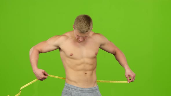 Male Athlete Measuring His Press Using Ruler, Green Screen Studio