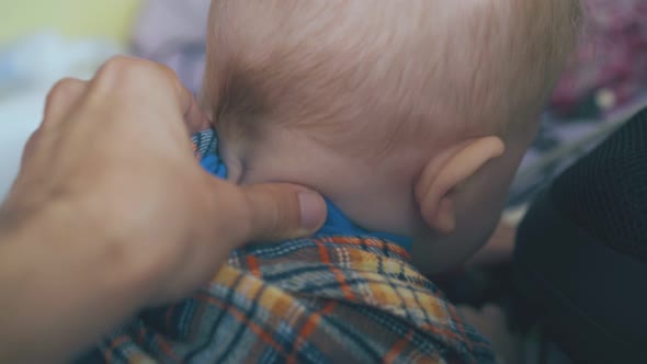 Mother Does Massage to Little Baby in Checkered Shirt on Bed