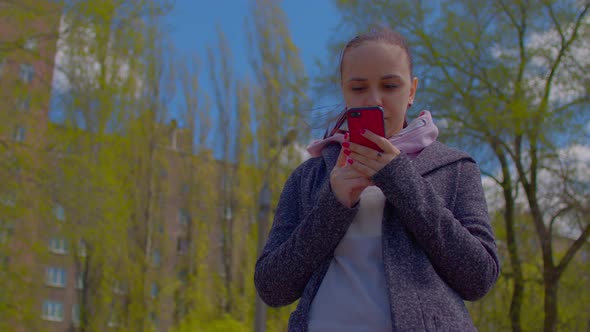 Close Up of Young Woman with Mobile Phone on Street in Sunny Weather