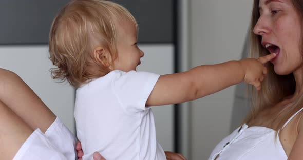 Adorable Infant Baby Girl Daughter Playing Patty Cake with Young Caucasian Mother at Home