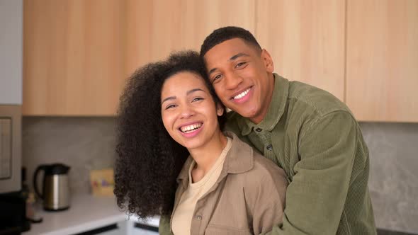 Closeup of Happy Multiracial Couple Posing While Standing at the Kitchen with Blurred Background