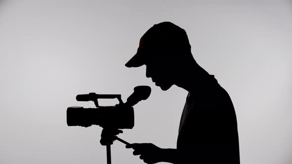 Silhouette of a Videographer with a Camera