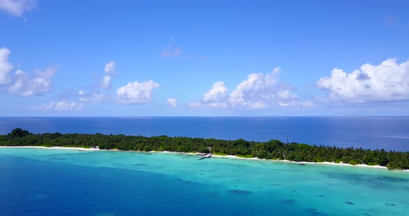 Beautiful flying abstract shot of a sunshine white sandy paradise beach and blue ocean background in