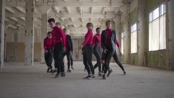 Dancing Band of Young Girls and Guys in Pink Costumes Synchronously Performing Movements