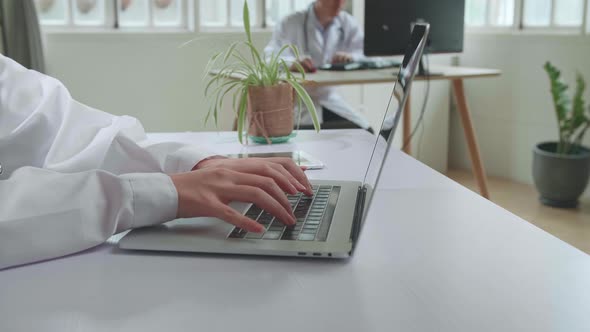 Close Up Young Asian Woman Doctor Is Using Laptop In Workplace. Medical Concept