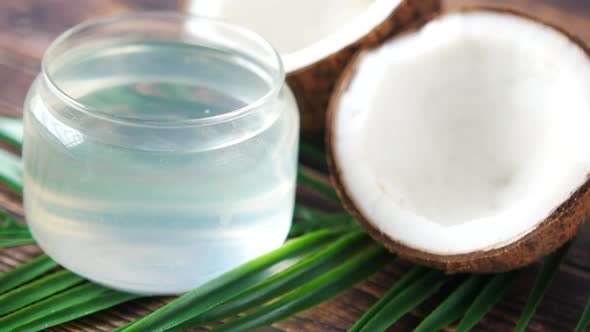 Slice of Fresh Coconut and Bottle of Oil on a Table