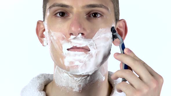 Man Shaves Cheek Using Razor Blades. White Background. Slow Motion