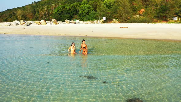 Young Smiling Ladies on Holiday Having Fun at The Beach on Summer White Sand and Blue