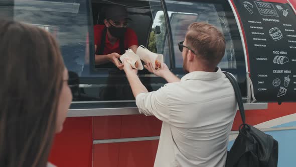 Couple Buying Hot Dogs from Food Truck