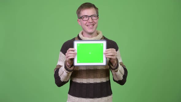 Young Happy Handsome Man Thinking While Showing Digital Tablet