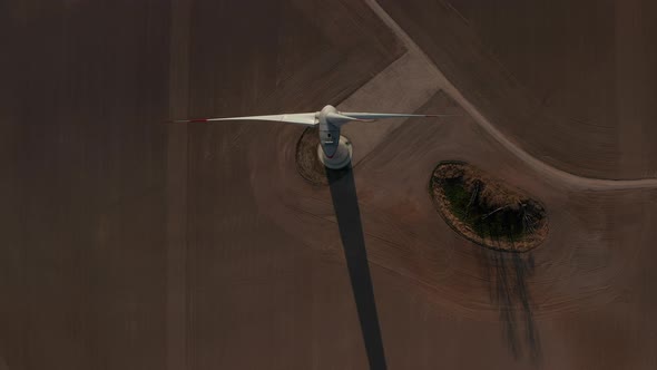 AERIAL: Close Up Overhead Shot of Wind Turbine, Mill Rotating By the Force of the Wind Generating