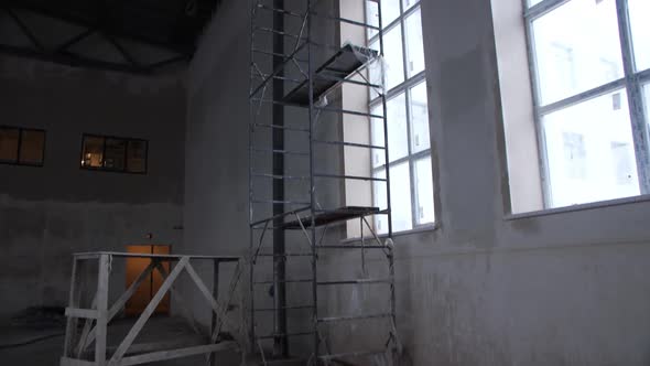 High Scaffolds Near Large Window in Empty Plant Workshop