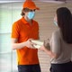 Delivery man with face mask and uniform send delivering order bag in front of customer house - VideoHive Item for Sale