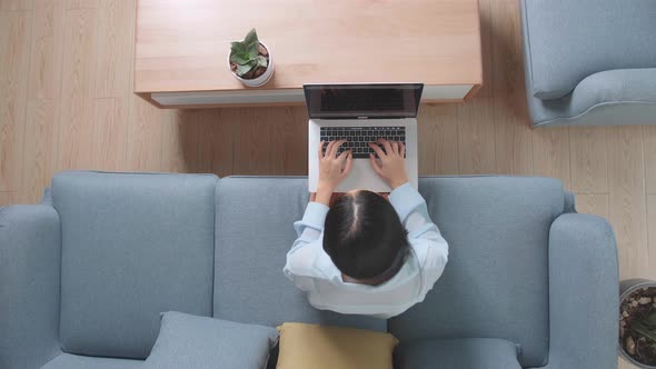 Top View Woman Sitting Sofa And Use Laptop Computer In Home Living Room