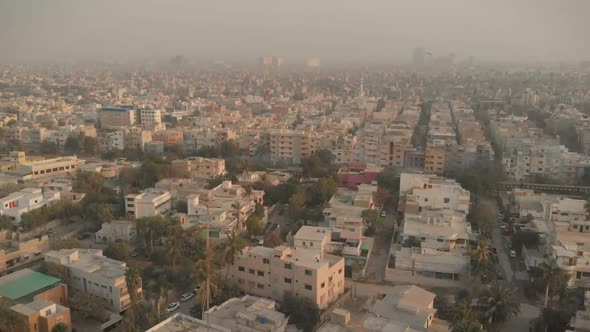 Aerial Over Smog Filled Karachi With Train Going Past Below. Follow Shot