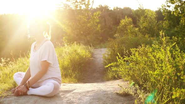 Fitness Young Woman Is Sitting Bound Angle Pose Outside in Park Evening on Background of Sunray