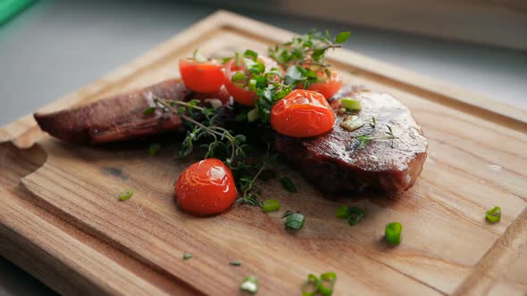 ready-made dish of the restaurant from the chef. a piece of baked meat with tomatoes on a wooden boa