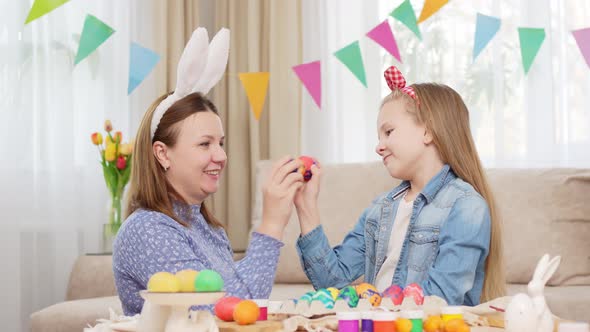 Mother and Sweet Daughter Play with Easter Eggs in Game of Who Will Break