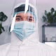 Portrait of Female Doctor Wearing Disposable Medical Suit Mask and Shield Against COVID19 Pandemic - VideoHive Item for Sale