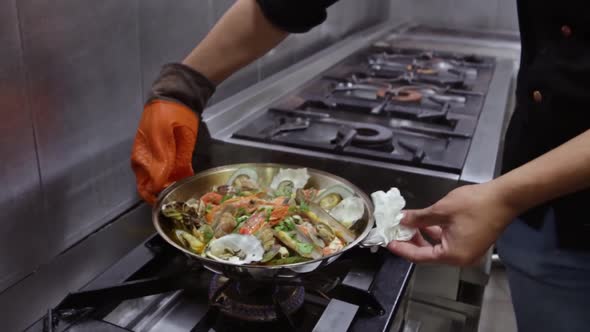 The Chef Removes the Cooked Cataplan with Octopus Seafood Vegetables and Sweet Potatoes From the