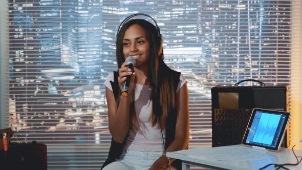 Pretty Black Girl in Headphone Singing Into Microphone and Recording a Song in Home Studio