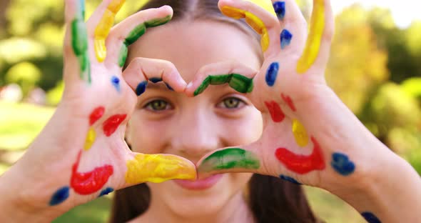 Happy girl with hands painted in water colors alt